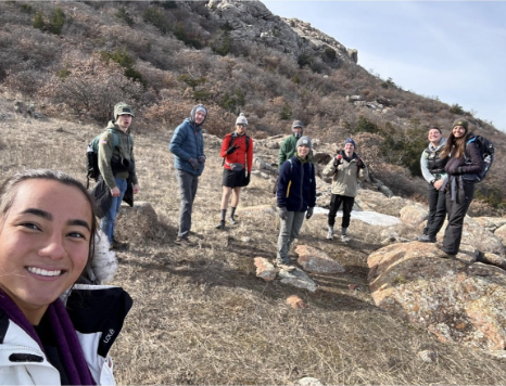 Campers (from left to right: Emma Burgess, Grady Geihsler, Skyler Cloudy, James Brandt, Matthew Moyer, Caroline Michem, Trevor Peyronnin, Emily Tumilty and Caroline Cutrona) pose for a picture in the Wichita Mountains, Saturday, Jan. 20, 2024. (Credit: Emma Burgess)